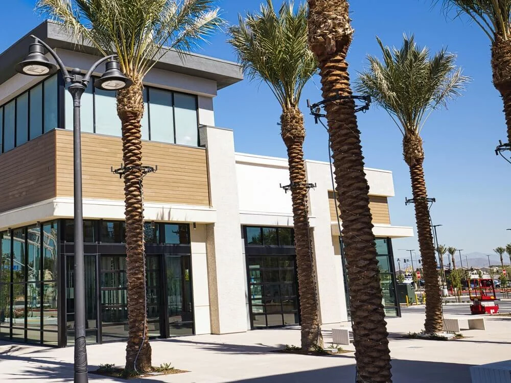 Stand-alone commercial building with large glass windows, palm trees, and modern architecture. Ideal for retail, restaurant, or office HVAC services