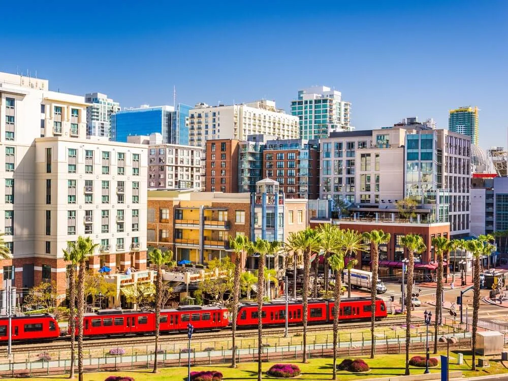 Downtown San Diego with trolley and mixed-use buildings, highlighting commercial to residential conversions in California.