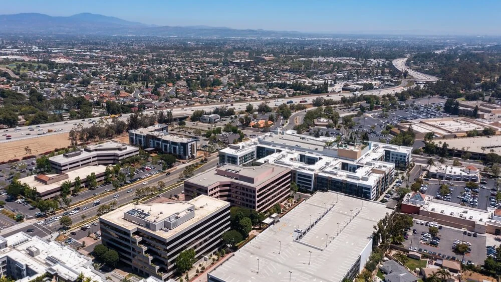 Aerial view of commercial office buildings and multi-family properties in Orange County, California.