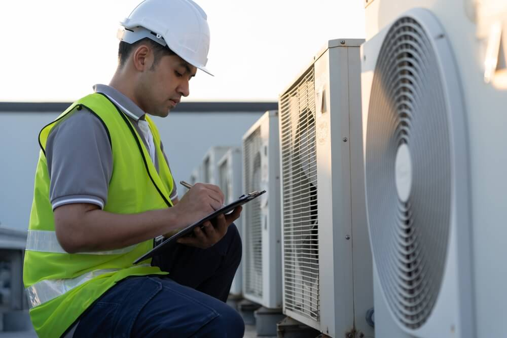 Technician inspecting a commercial rooftop HVAC in San Diego to evaluate whether repair or replacement is the best option.